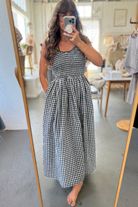 Woman wearing a black and white checkered dress in a store setting.