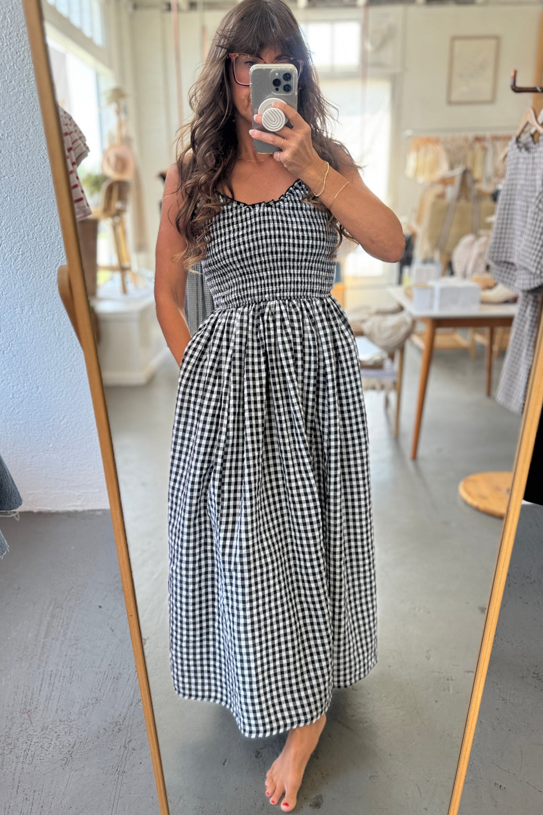 Woman wearing a black and white checkered dress in a store setting.