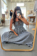 Load image into Gallery viewer, Woman wearing a black and white checkered dress in a store setting.