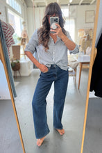 Load image into Gallery viewer, Person taking a mirror selfie wearing a striped shirt and blue jeans in a room.