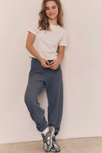 Load image into Gallery viewer, Person wearing a white t-shirt and blue pants against a plain background
