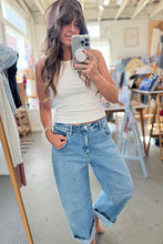 Load image into Gallery viewer, A woman takes a mirror selfie in a boutique, wearing a white ribbed tank top and light-wash wide-leg denim jeans.
