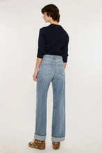 Load image into Gallery viewer, A model shown from the back wearing light-wash wide-leg jeans, a dark navy long-sleeve top, and brown suede shoes against a plain white studio background.
