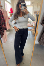 Load image into Gallery viewer, Person taking a mirror selfie wearing a gray long-sleeve top and black pants in a clothing store.