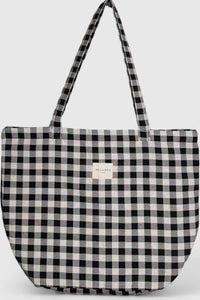 Black and white checkered tote bag with a visible brand label on a light gray background