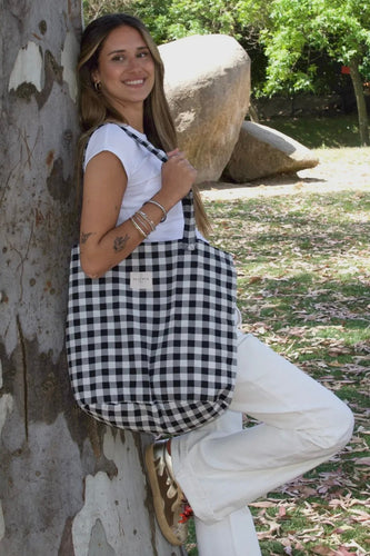 Woman leaning against a tree in a park-like setting