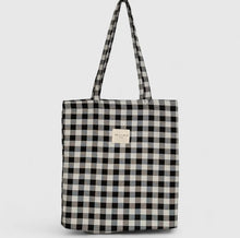 Load image into Gallery viewer, Black and white checkered tote bag with a visible brand label on a light gray background