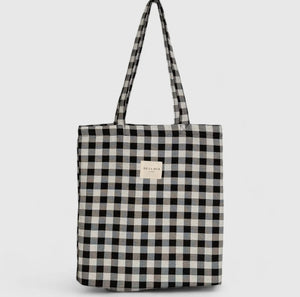 Black and white checkered tote bag with a visible brand label on a light gray background