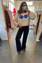 Load image into Gallery viewer, Person wearing a sweater with fish designs in a clothing store.