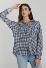 Load image into Gallery viewer, Woman wearing a black and white checkered shirt and blue jeans against a plain background
