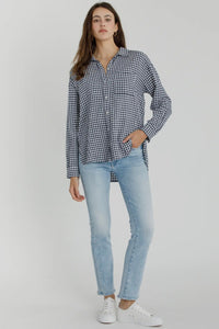 Woman wearing a checkered shirt and light blue jeans on a white background