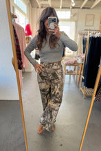 Load image into Gallery viewer, Person taking a mirror selfie wearing a gray long-sleeve top and camouflage pants in a clothing store.