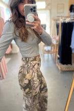 Load image into Gallery viewer, Person taking a mirror selfie wearing a gray long-sleeve top and camouflage pants in a clothing store.