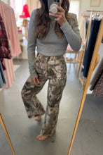 Load image into Gallery viewer, Person wearing a gray long-sleeve top and camouflage pants in a store setting.