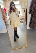 Load image into Gallery viewer, Person taking a mirror selfie wearing a light-colored dress and black boots in a clothing store.
