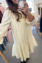 Load image into Gallery viewer, Person wearing a light yellow dress with long sleeves in a store setting.