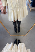 Load image into Gallery viewer, Person wearing a white dress and black boots standing in front of a mirror.