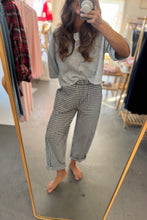 Load image into Gallery viewer, Person taking a mirror selfie wearing a gray top and checkered pants in a clothing store.