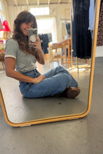 Load image into Gallery viewer, Person taking a mirror selfie wearing a gray t-shirt and blue jeans in an indoor setting.