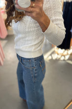 Load image into Gallery viewer, Person wearing a white sweater and blue jeans in a store setting