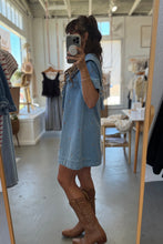 Load image into Gallery viewer, Person wearing a denim dress and brown boots in a clothing store.