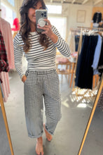 Load image into Gallery viewer, Person taking a mirror selfie wearing a striped top and checkered pants in a clothing store.