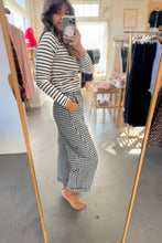 Load image into Gallery viewer, Person taking a mirror selfie wearing a striped top and checkered pants in a clothing store.