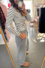 Load image into Gallery viewer, Person taking a mirror selfie wearing a striped long-sleeve top and checkered pants in a clothing store.