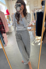 Load image into Gallery viewer, Person wearing a striped shirt and checkered pants in a clothing store.