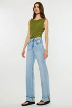 Load image into Gallery viewer, A woman modeling a sleeveless olive green top and light-wash wide-leg blue jeans with black sandals, standing against a plain white studio background.