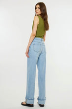 Load image into Gallery viewer, A woman wearing light-wash wide-leg denim jeans and an olive green sleeveless top, shown from the back against a plain white studio background.