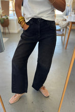 Load image into Gallery viewer, Person wearing black high-waisted jeans and a white top indoors.