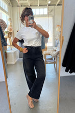 Load image into Gallery viewer, Person taking a mirror selfie wearing a white top and black pants in a room with a mirror and clothing.