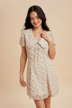 Load image into Gallery viewer, Woman wearing a floral dress against a beige background