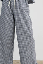 Load image into Gallery viewer, Black and white gingham wide-leg pants with a white drawstring waist, shown on a model against a light gray wall.