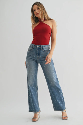 Woman wearing a red top and blue jeans on a white background
