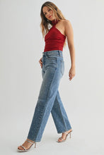 Load image into Gallery viewer, Woman wearing a red halter top and blue jeans on a white background