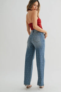 Woman wearing a strapless red top and blue jeans on a white background