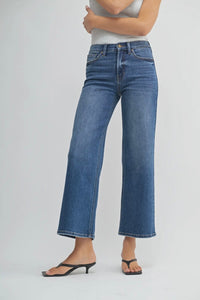 Person wearing blue jeans on a plain background