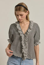 Load image into Gallery viewer, Woman wearing a black and white checkered blouse with lace details on a beige background