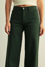 Load image into Gallery viewer, A person wearing dark forest green wide-leg jeans with a cream ribbed crop top, shown from the waist down against a light beige studio background.