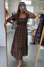 Load image into Gallery viewer, Woman taking a mirror selfie wearing a brown plaid dress in a store.
