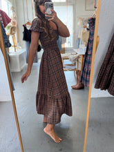 Load image into Gallery viewer, Person wearing a brown checkered dress in a store setting