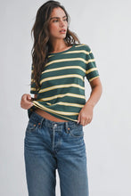 Load image into Gallery viewer, Woman wearing a green and yellow striped shirt with blue jeans on a plain background