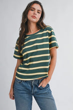 Load image into Gallery viewer, Woman wearing a green and yellow striped t-shirt with blue jeans on a plain background