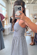 Load image into Gallery viewer, Person wearing a blue and white striped dress taking a mirror selfie in a store.