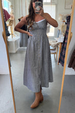 Load image into Gallery viewer, Person wearing a striped dress standing in front of a mirror in a room with furniture.