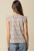 Load image into Gallery viewer, A woman shown from the back wearing a sleeveless plaid top with ruffled shoulder details and blue jeans, against a plain beige studio background.