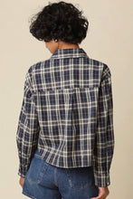 Load image into Gallery viewer, A person shown from the back wearing a navy and off-white plaid button-up shirt with blue denim shorts, set against a plain beige background.