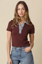 Load image into Gallery viewer, A woman modeling a short-sleeve knit polo shirt in deep burgundy with a light blue denim collar and placket, paired with blue jeans against a solid beige background.